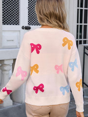 Cream knit sweater with multicolor bow motif, crew neck, long sleeves.