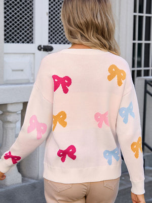Cream knit sweater with multicolor bow motif, crew neck, long sleeves.