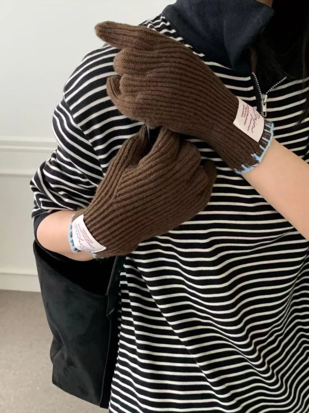 Brown ribbed knit gloves with scalloped cuff and light blue trim detail.