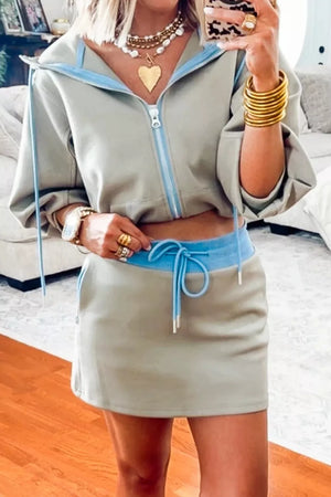 Cropped zip-up jacket and mini skirt ensemble with blue drawstring waist and trim.