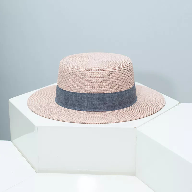 Woven straw boater hat in pink with a grey ribbon band.