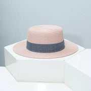 Woven straw boater hat in pink with a grey ribbon band.