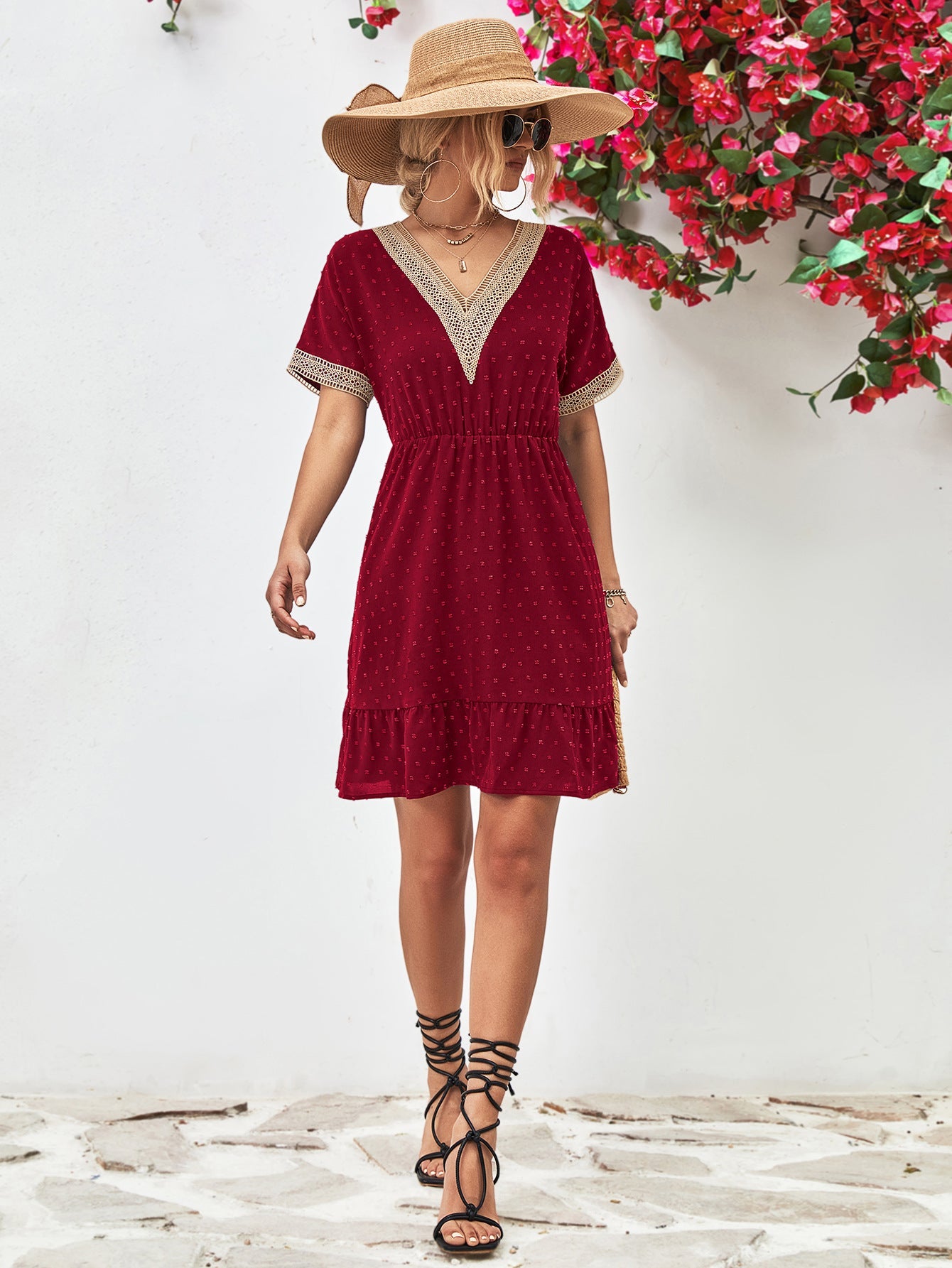 Burgundy A-line dress with Swiss dots, V-neck, crochet trim, and ruffled hem.