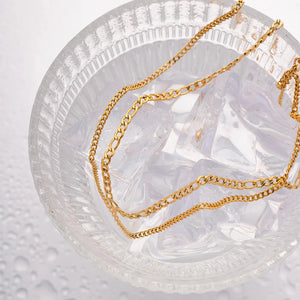 Gold dual-strand curb chain necklace with two distinct link styles.