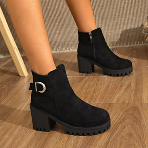 Black suede ankle boots with round toe, block heel, side zipper, and decorative buckle detail.
