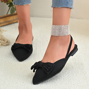 Black slingback flats with bow detail and pointed toe.