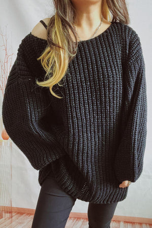 Black oversized ribbed knit sweater with boat neck and off-the-shoulder styling.