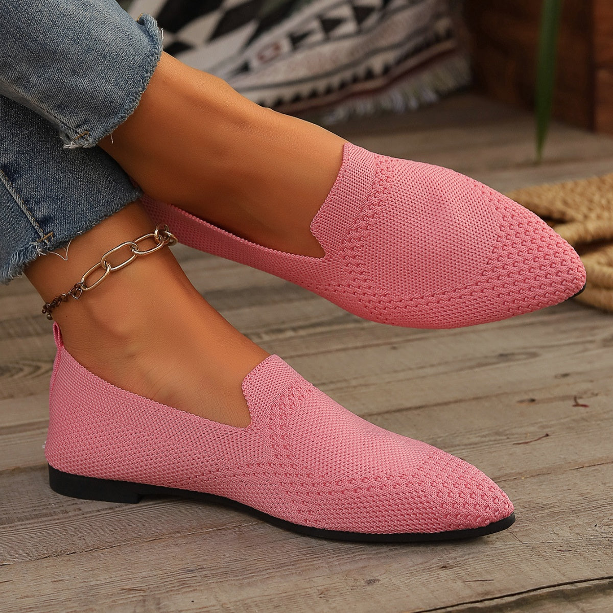 Pink breathable pointed-toe knit flats with a casual slip-on style.