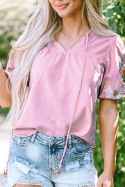 Dusty pink peasant blouse with embroidered puff sleeves and tie neckline.