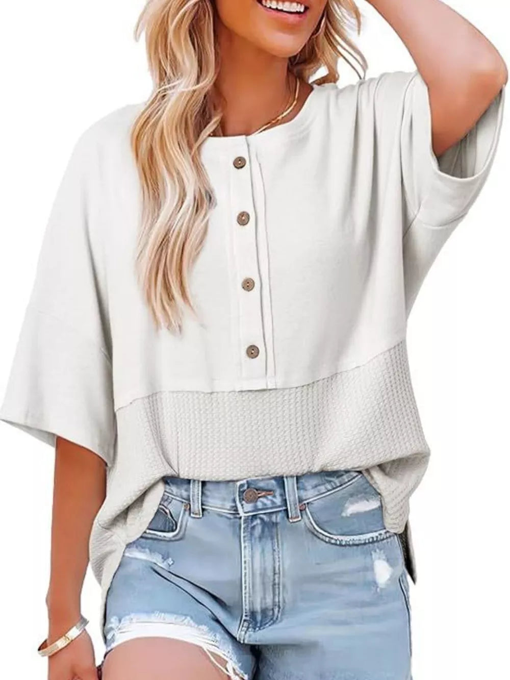 White waffle-knit t-shirt with button detail and contrasting textured hem.