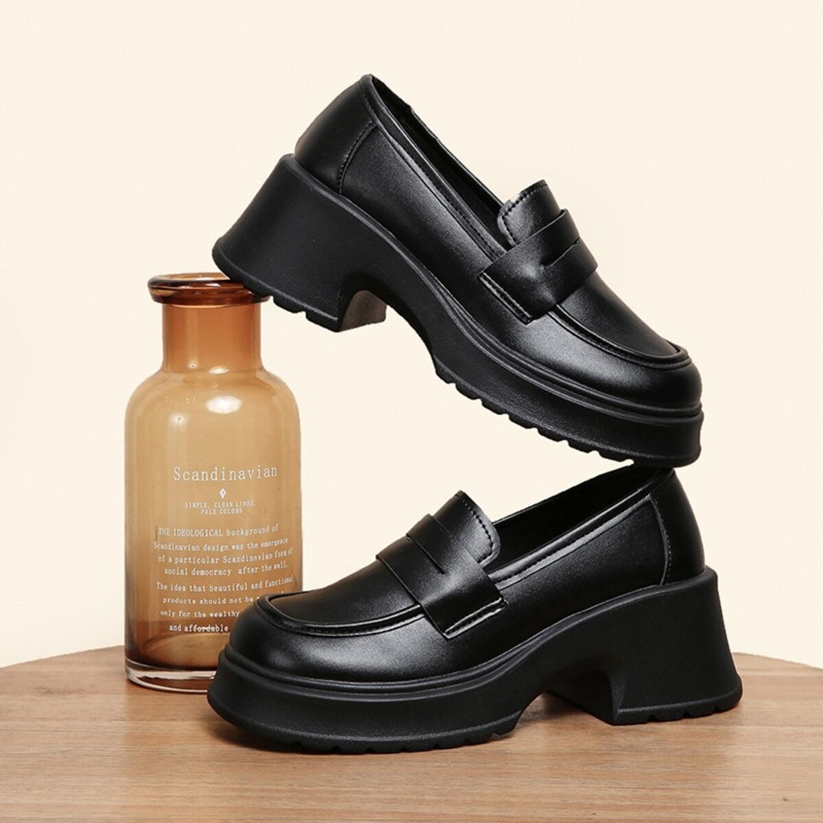 Black round toe block heel loafers with a chunky sole and classic strap detail.