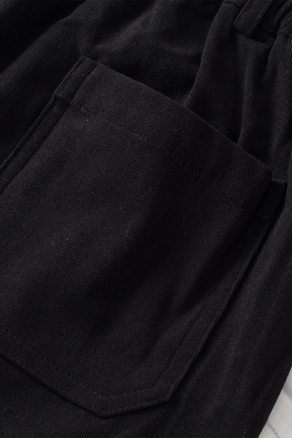 Black seamed front wide leg trousers with a visible pocket detail.