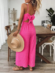 Rose red wide-leg romper with back bow detail and textured fabric.