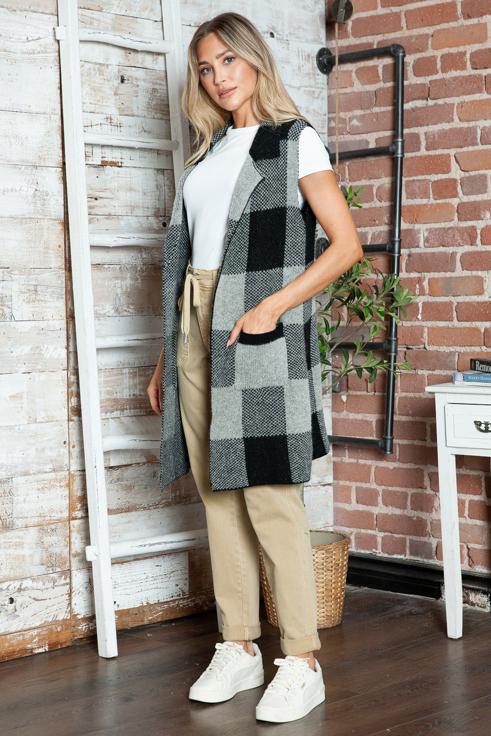 Black and gray checkered knit duster vest with pockets and a lapel.