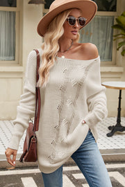 Beige off-the-shoulder distressed knit sweater with boat neck and cable knit details.