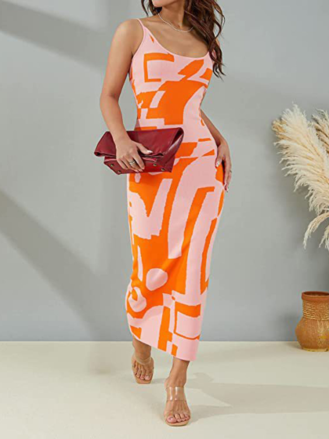 Geometric knit maxi slip dress in orange and pink abstract print with spaghetti straps.