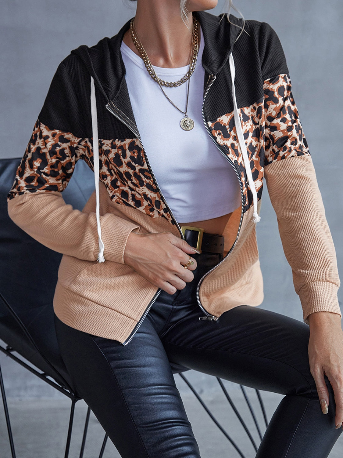 Colorblock leopard zip-up hoodie with black, tan, and leopard print panels.