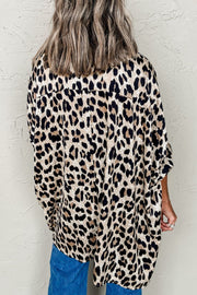 Leopard print oversized button-down blouse with rolled sleeves, worn casually.