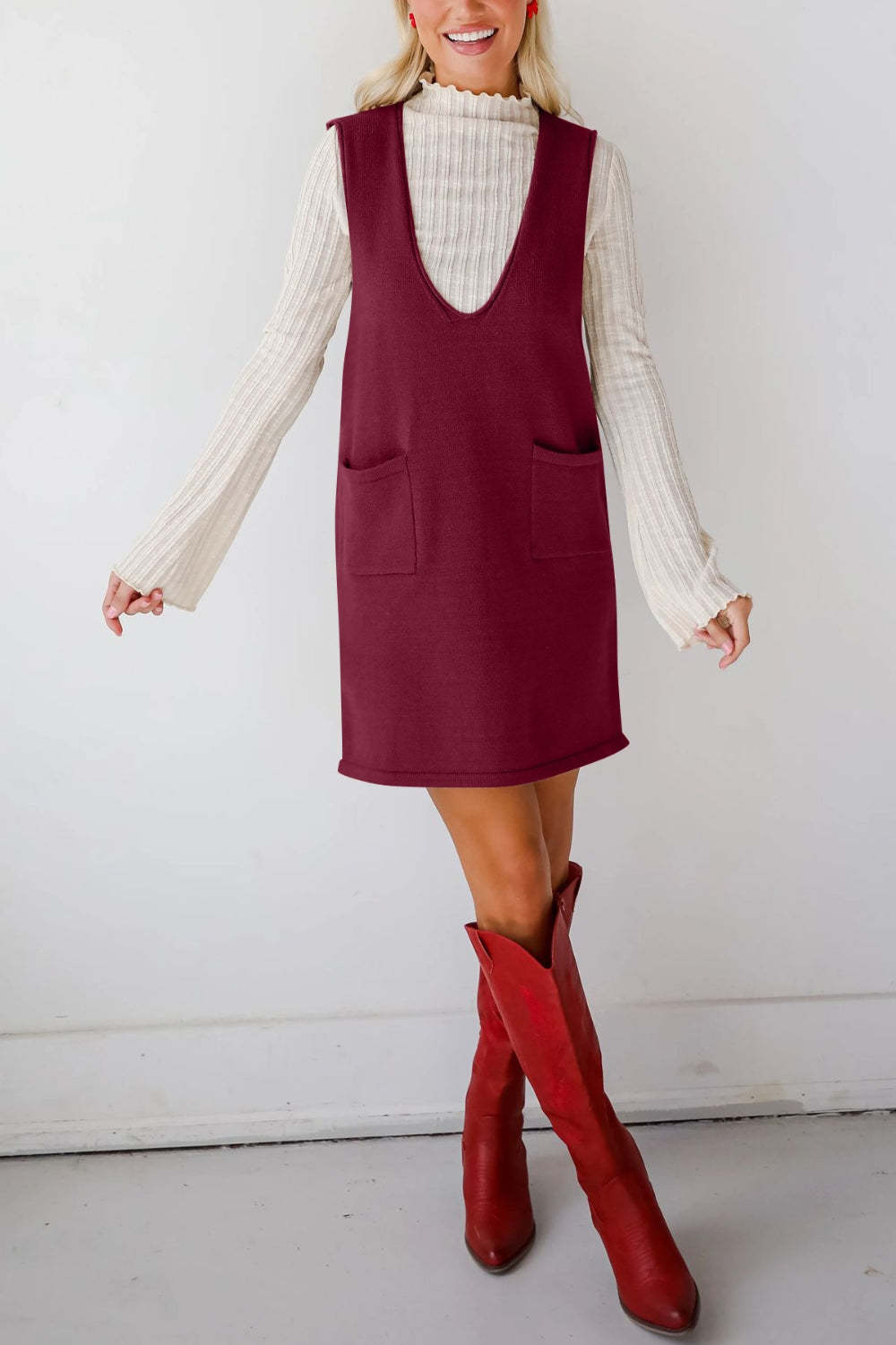 Burgundy knit sweater dress with deep V-neck and two front pockets.