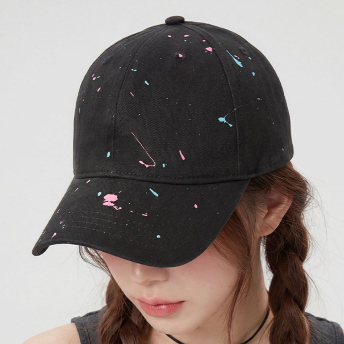Black cotton baseball cap with pink and blue splatter paint detail
