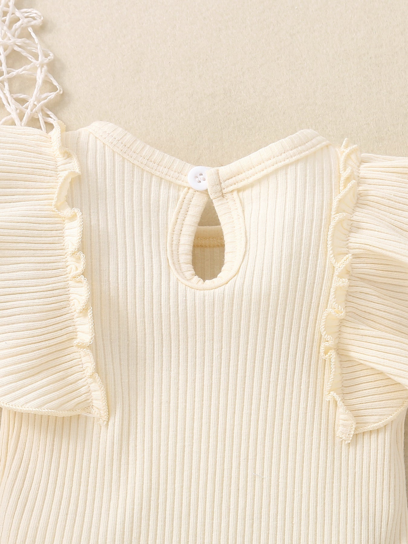 Ribbed baby set in cream with ruffle trim sleeves and keyhole back detail.