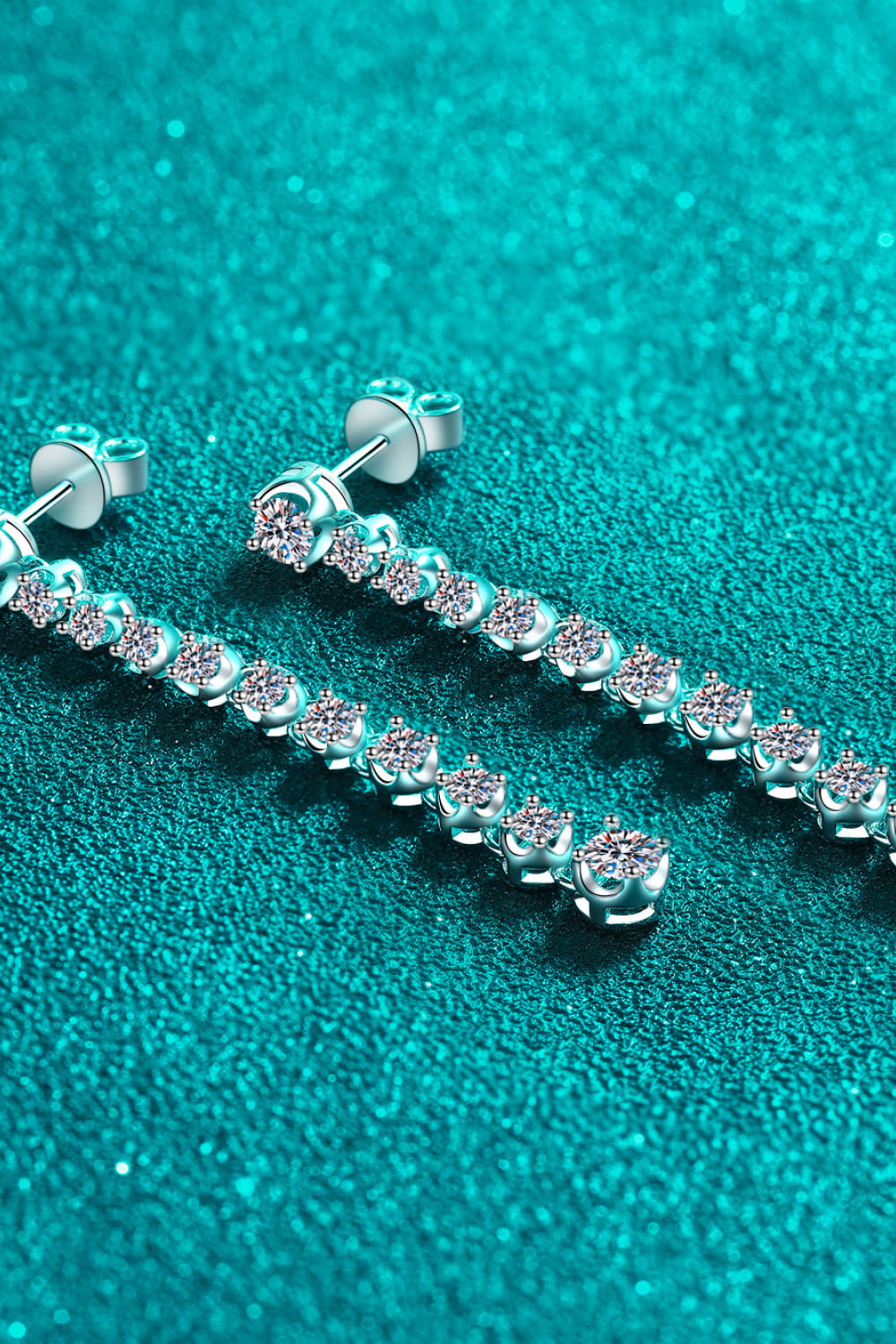 Silver moissanite linear drop earrings with multiple sparkling stones.