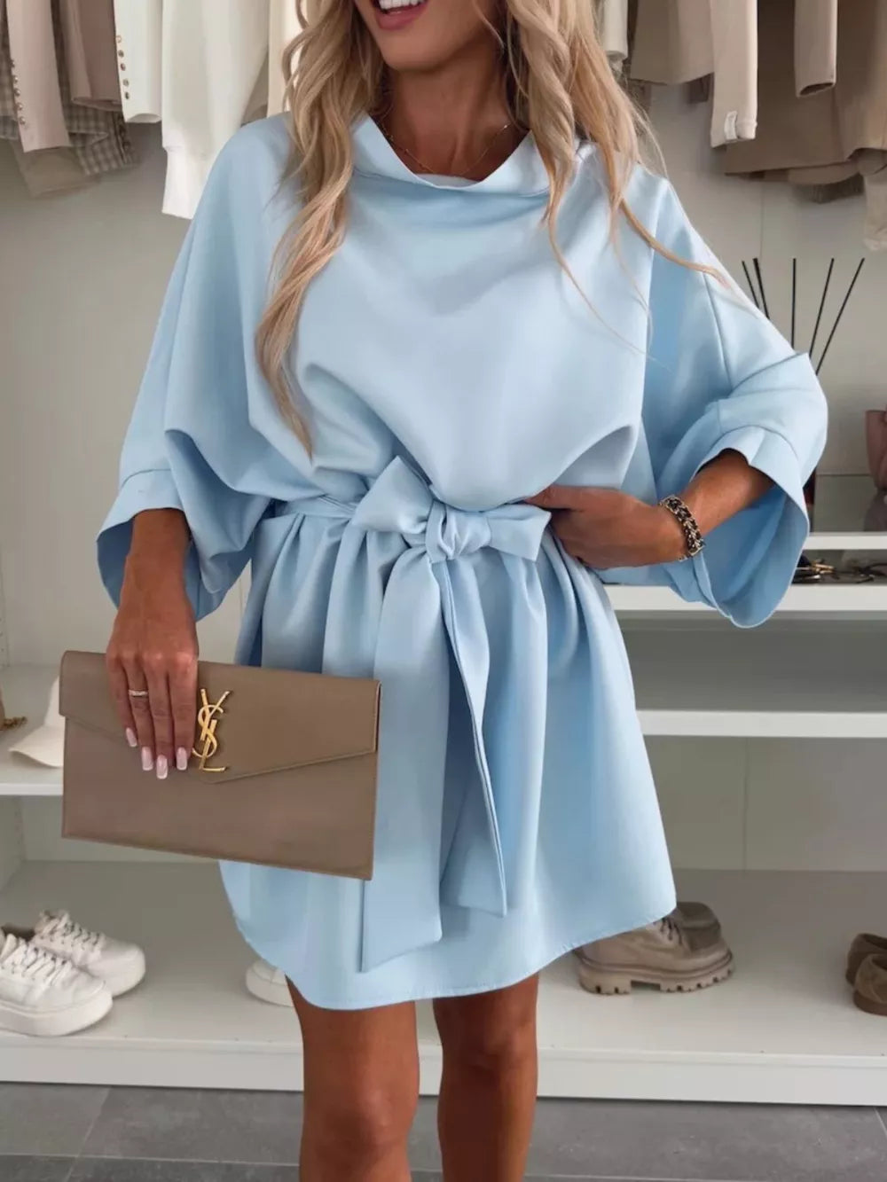 Light blue mini dress with batwing sleeves, a tie waist, and a cowl neck.