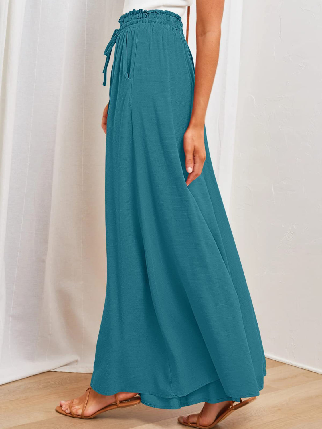 Textured drawstring palazzo trousers in deep teal with pockets and a cinched waist.