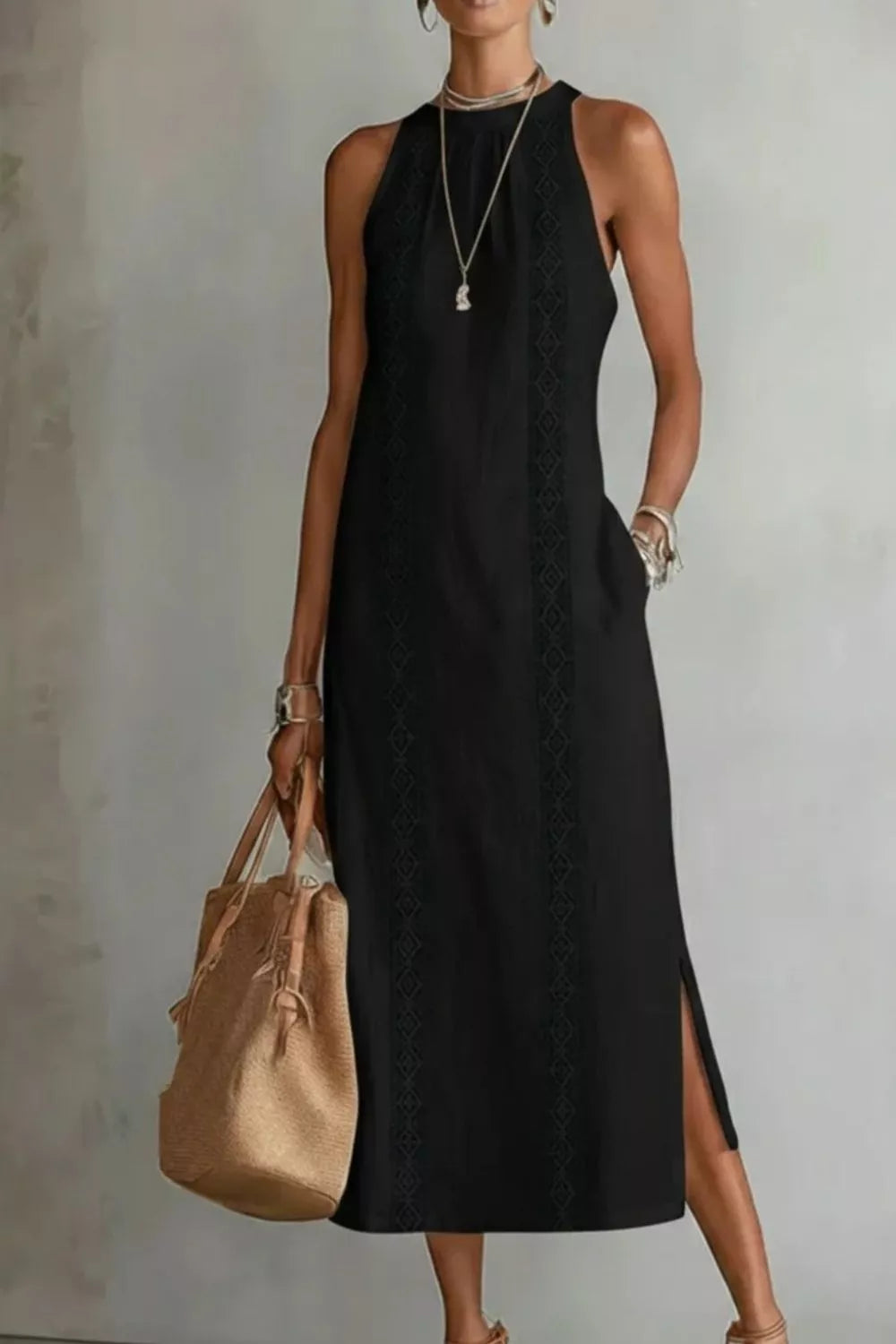 Black midi dress with pockets, sleeveless, high neck, and side slits.