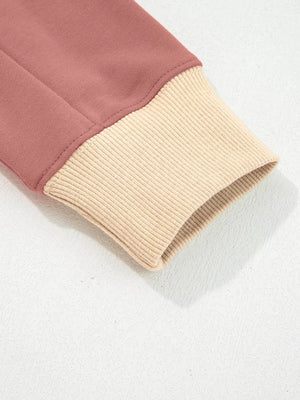 Dusty pink sweatshirt cuff with beige ribbed knit detail and exposed seams.