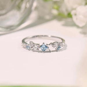 Silver ring with celestial cluster of blue square and clear round cubic zirconia stones and star details.
