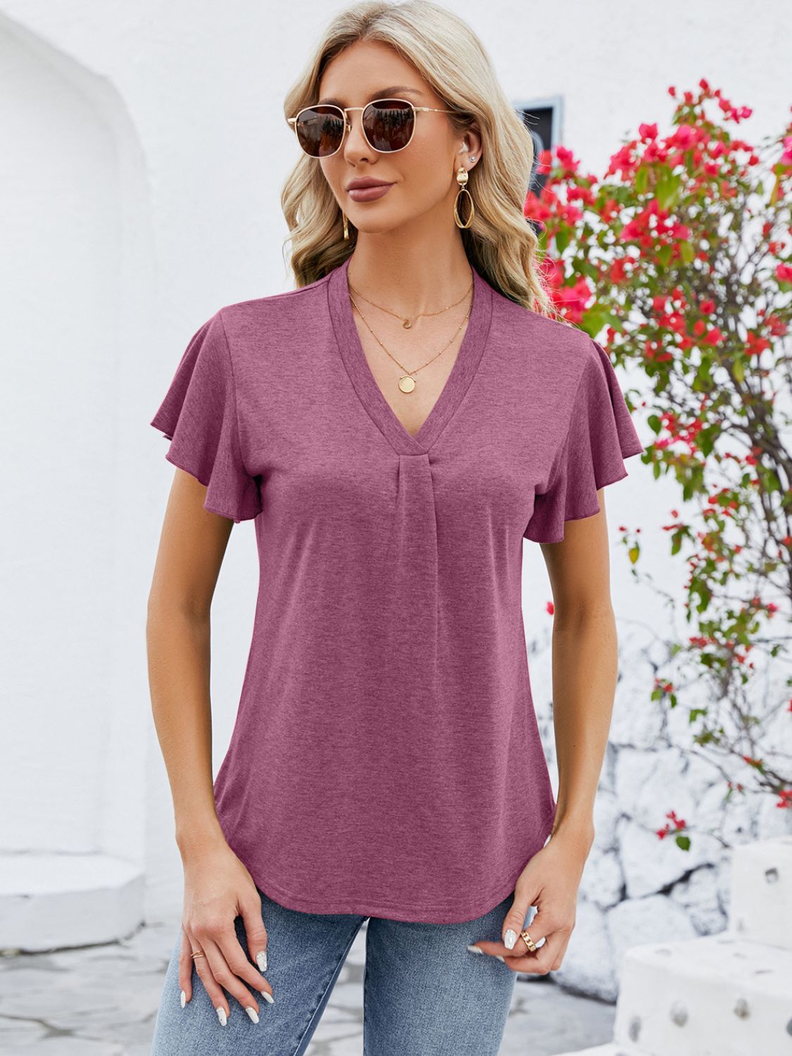 V-neck pleated flutter sleeve top in a muted coral hue, featuring a casual, relaxed fit.