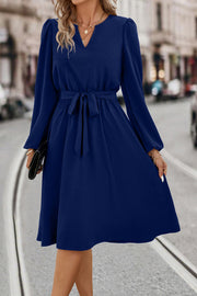 Navy midi dress with V-neck, poet sleeves, and tie waist