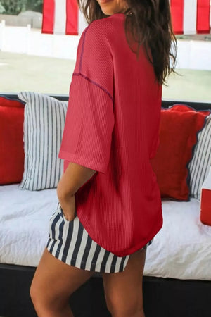 Red ribbed t-shirt with crew neck and short sleeves, featuring contrast stitching.
