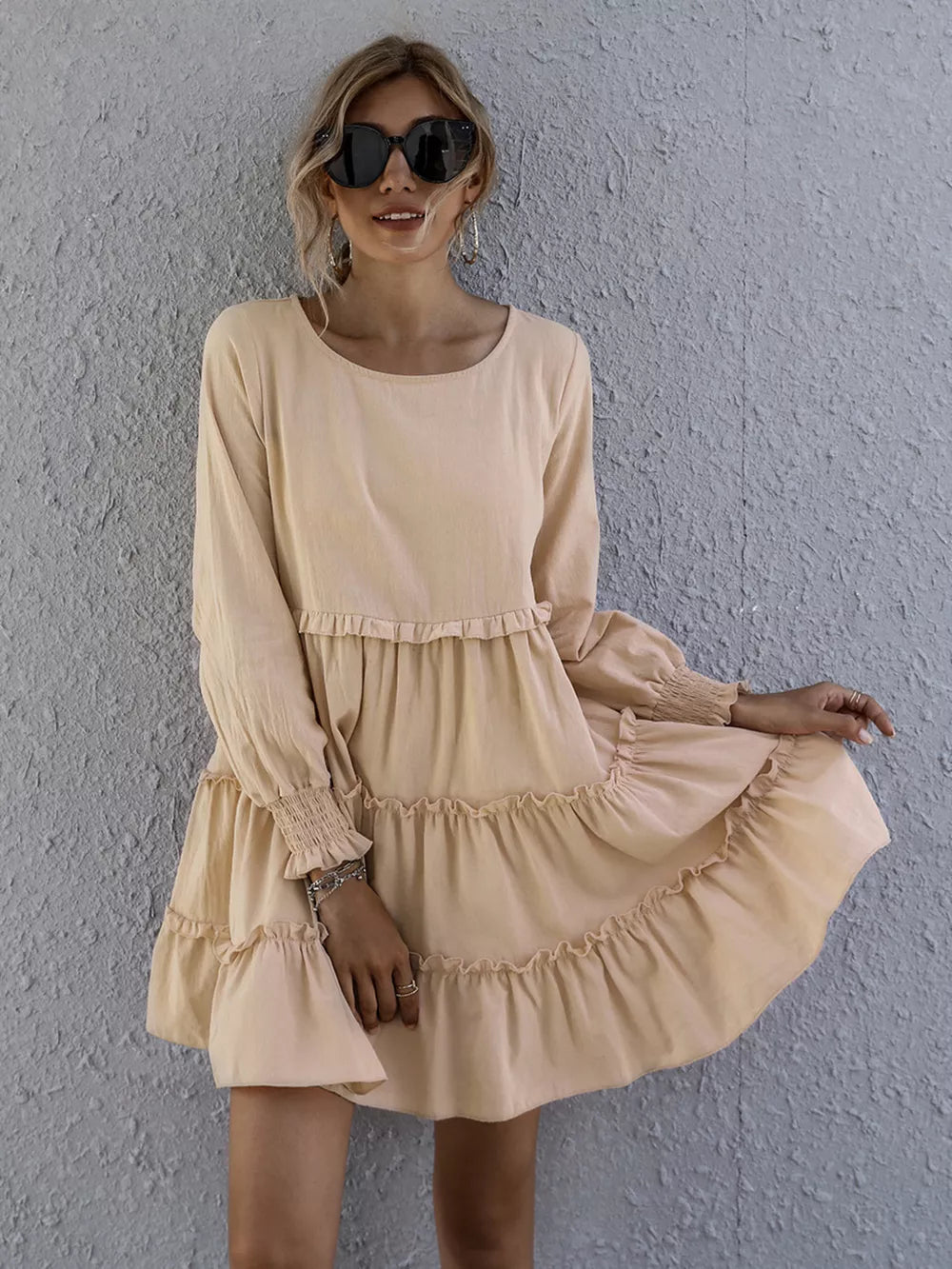 Apricot ruffled mini dress with long sleeves and smocked cuffs.