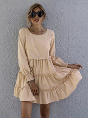 Apricot ruffled mini dress with long sleeves and smocked cuffs.