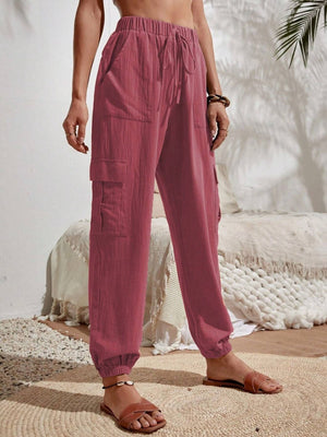 Textured cargo lounge trousers in dusty pink with drawstring waist and multiple pockets.