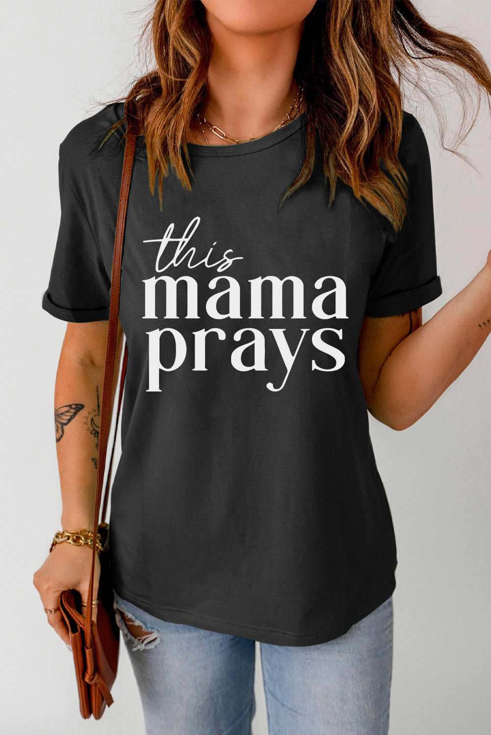 Black graphic tee with white script text that says "this mama prays".