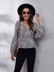 Black and white leopard print peplum blouse with gathered waist and balloon sleeves.