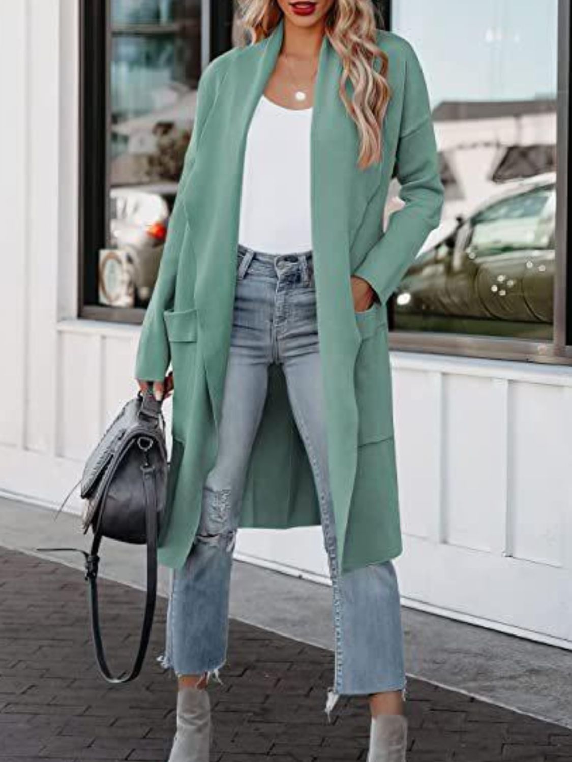 Relaxed-fit open-front duster cardigan in a muted green with pockets and long sleeves.