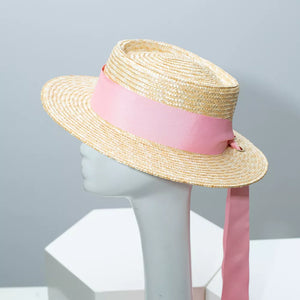 Classic straw boater hat with pink ribbon and long trailing ribbon.