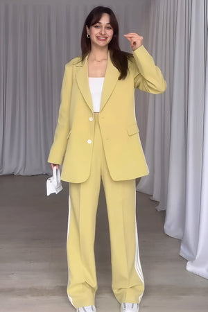 Pastel yellow pant suit with track stripes on the pants and a matching blazer.