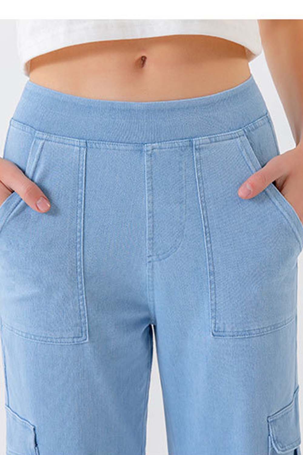 Light wash denim cargo pants with front pockets and utility details.