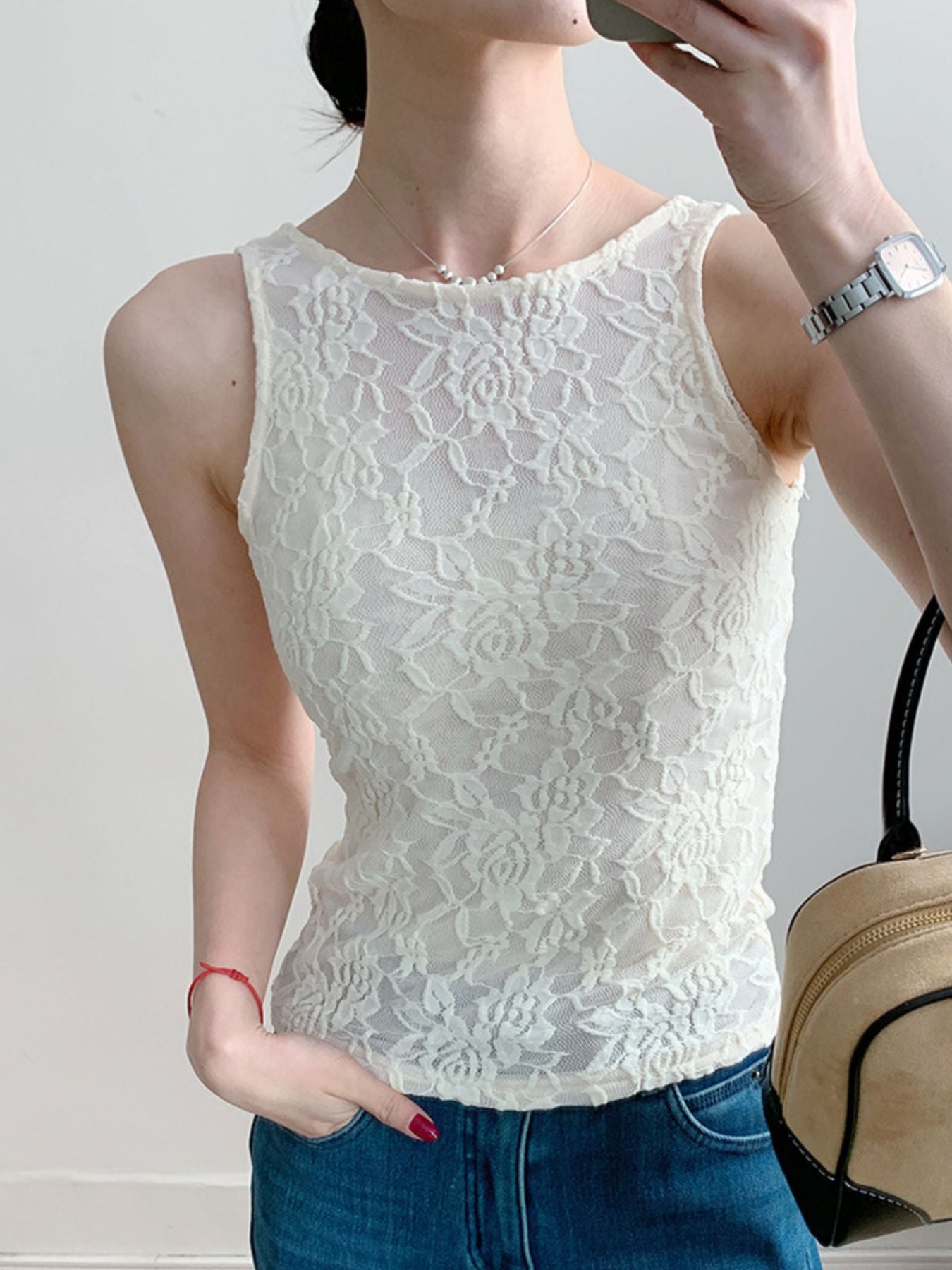 White lace tank top with floral pattern and sheer detail.