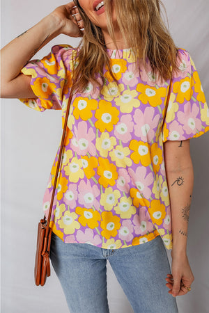 Puff sleeve blouse with ruffle trim and a bold floral print in yellow, pink, and purple.