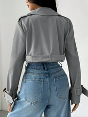 Gray cropped double-breasted trench coat with belt and adjustable cuffs.