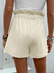 Cream textured paperbag shorts with tie waist and elastic waistband.