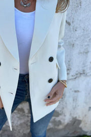 Ivory double-breasted blazer with sculpted lapels and dark buttons, styled with jeans.
