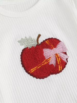White ribbed cotton bodysuit with a textured red apple applique and pink bow detail.