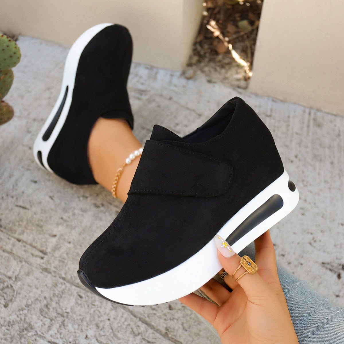 Black chunky platform sneakers with air cushion sole and hook-and-loop closure.